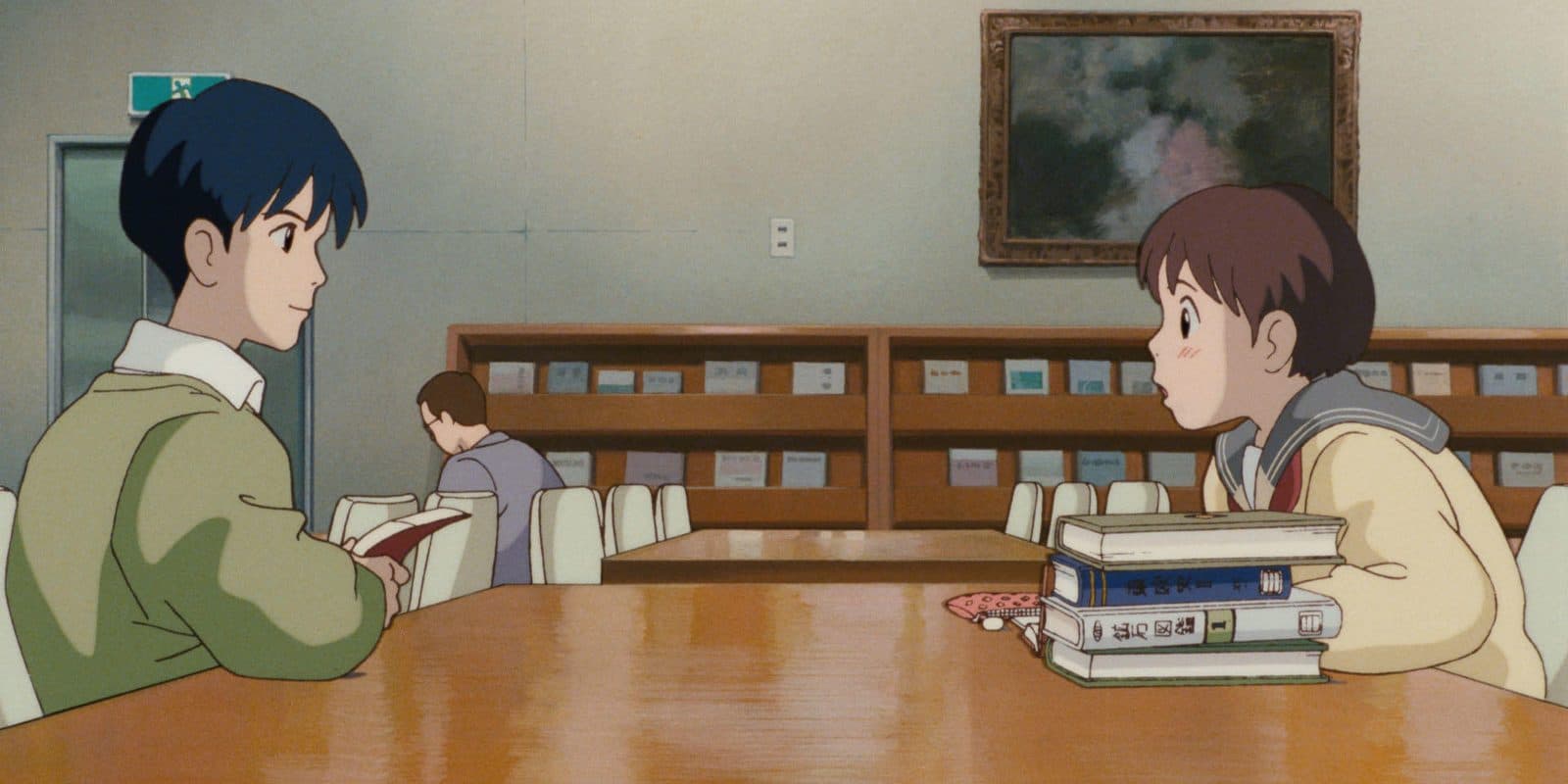 still from Whisper of the Heart: Shizuku and Seiji at a library table stacked with books