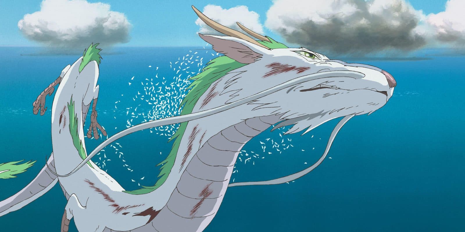 still from Spirited Away: the white dragon Haku flying low over bright blue water
