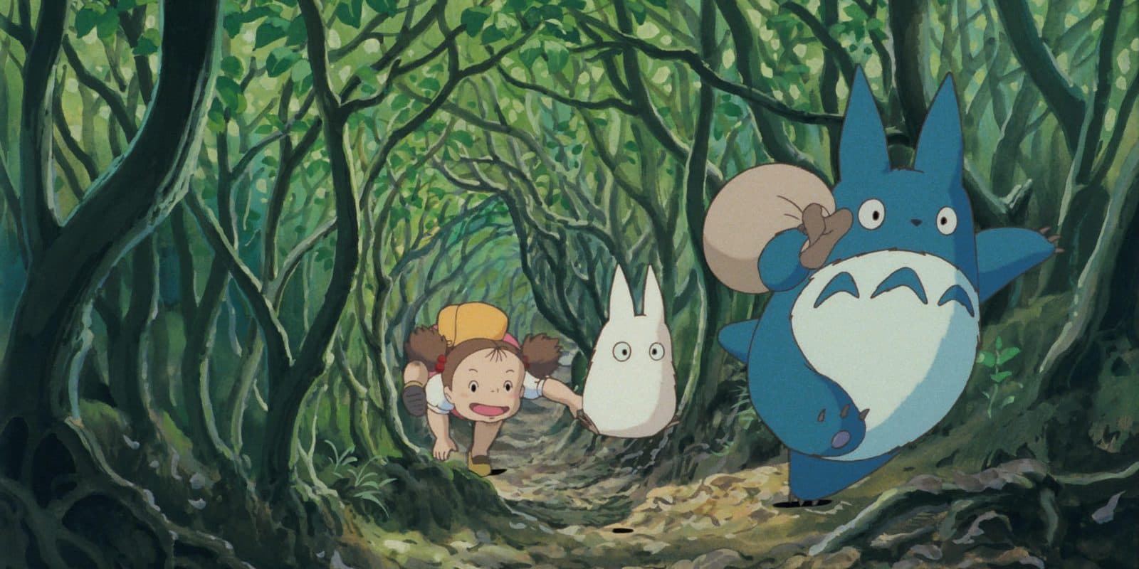 still from My Neighbor Totoro: Mei crawling through a leafy tunnel after two small Totoros